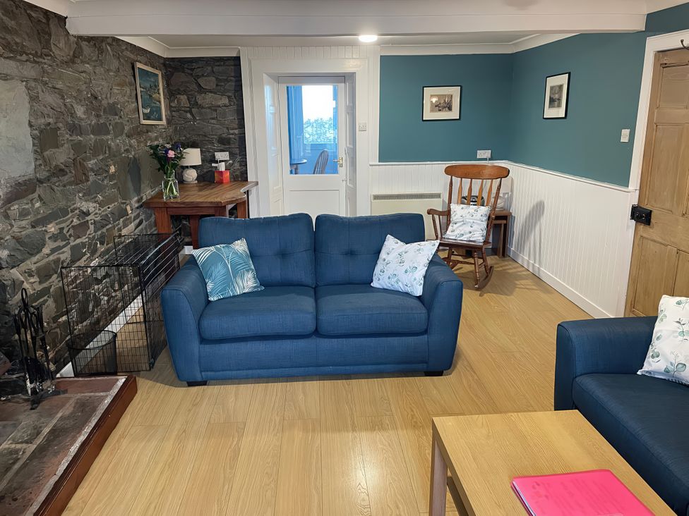 A living room with a sofa and coffee table at The Pink House in Isle Of Whithorn