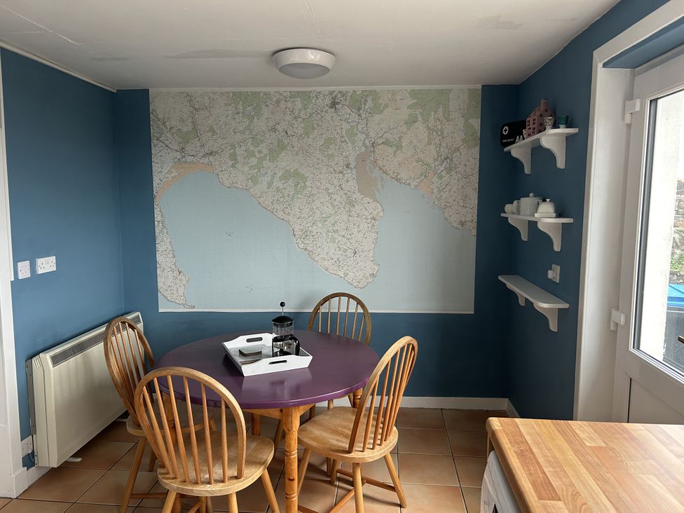A dining room with a table and chairs at The Pink House in Isle Of Whithorn