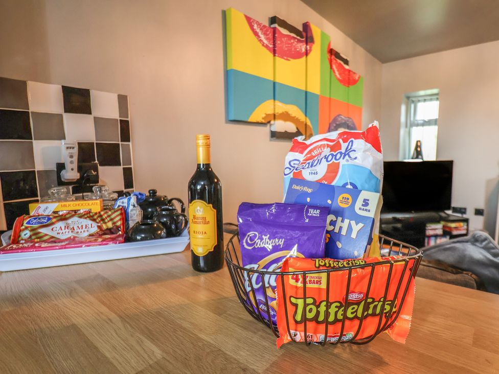 A kitchen with snacks and a bottle of wine at Fortunatus in Whitby