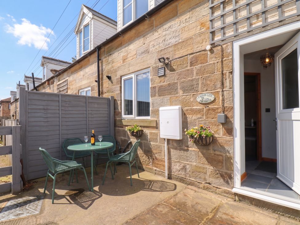 An outdoor seating area with a table and chairs at Fortunatus in Whitby