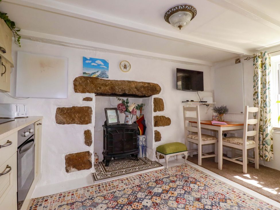 A kitchen with a table and chairs at Longview Cottage in Penwithick neat St Austell