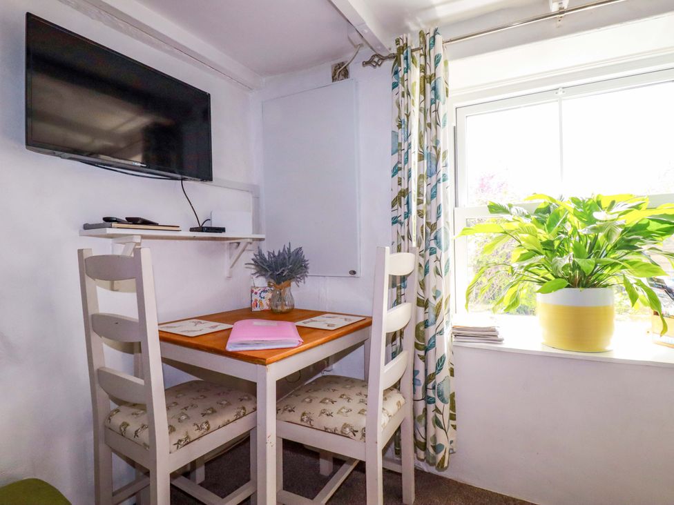A dining area with a table and chairs at Longview Cottage Penwithick near St Austell