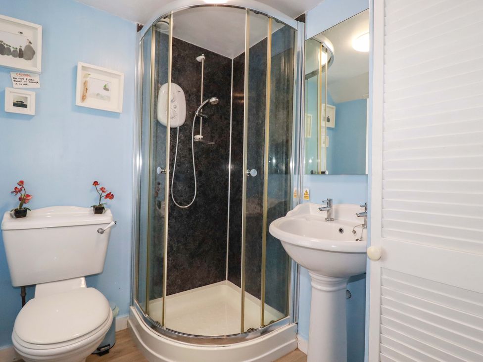 A bathroom with shower, sink, and toilet at Longview Cottage in Penwithick neat St Austell