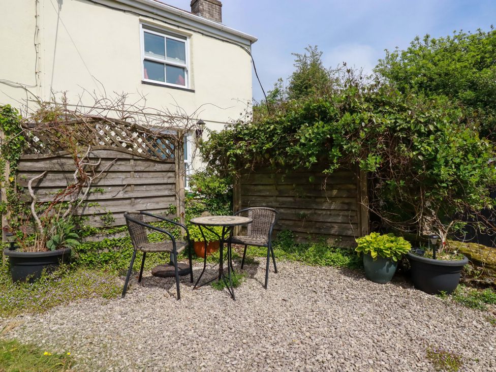 A garden with a table and chairs surrounded by plants at Longview Cottage Penwithick neat St Austell