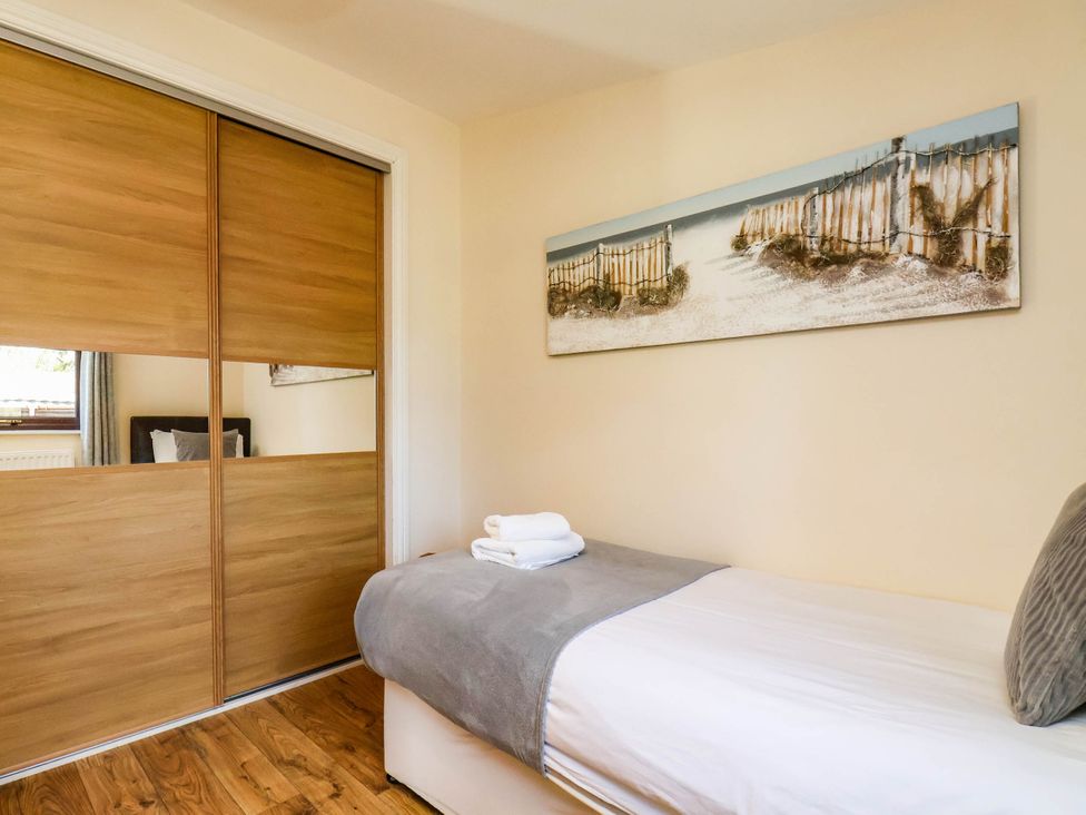 A bedroom with a single bed and wardrobe at Snowdrop in Saltburn-by-the-Sea