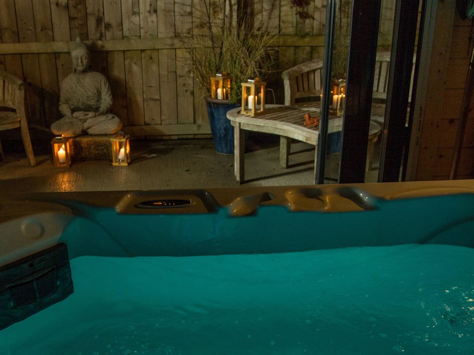 A hot tub and a buddha statue in an outdoor area at The Old Miners Hall Rookhope