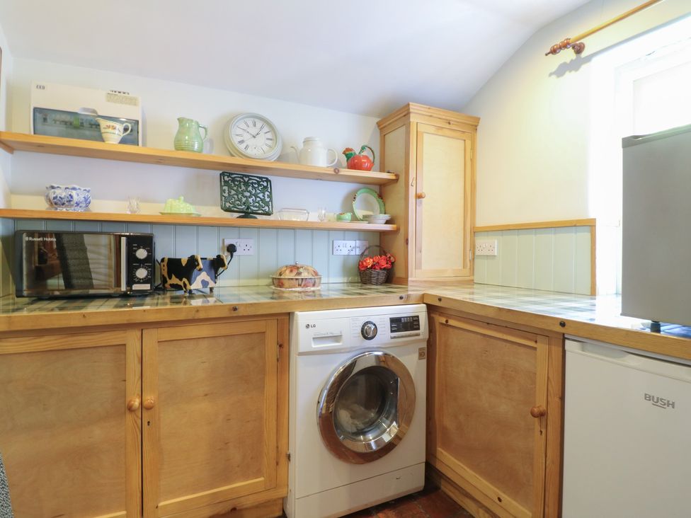 A kitchen with appliances and shelves at Just A Cottage, Newlands Farm in Golden Valley near Riddings and Alfreton