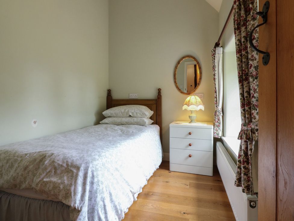 A bedroom with a bed and lamp at Just A Cottage, Newlands Farm in Golden Valley near Riddings and Alfreton