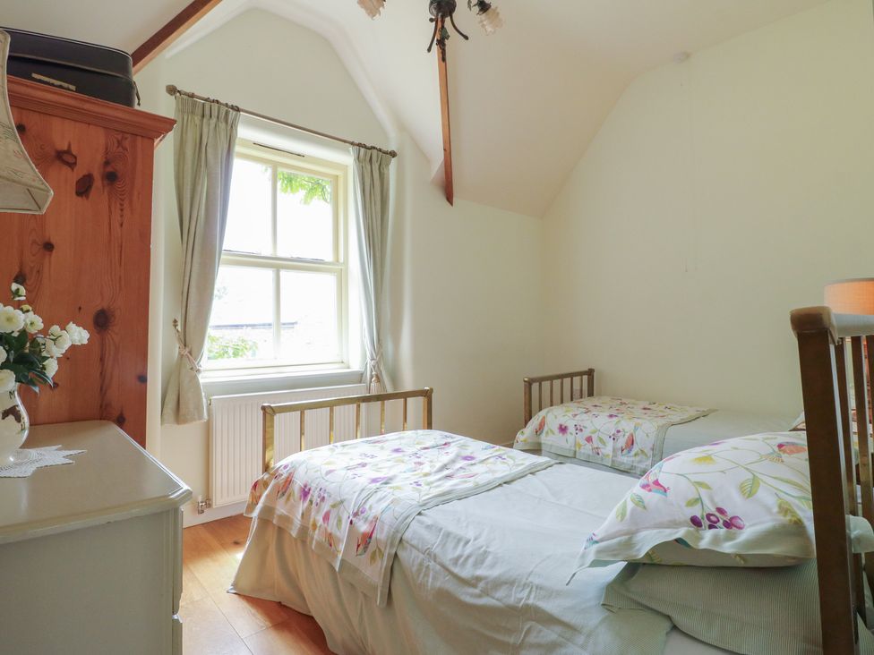 A bedroom with two beds and a window at Just A Cottage, Newlands Farm, Golden Valley near Riddings and Alfreton