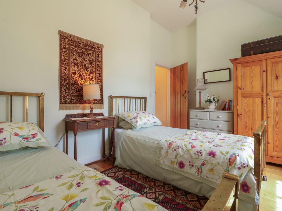 A bedroom with two beds and a bedside table at Just A Cottage, Newlands Farm, Golden Valley near Riddings and Alfreton