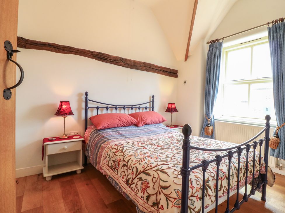 A bedroom with a bed and bedside table at Just A Cottage, Newlands Farm, Golden Valley near Riddings and Alfreton