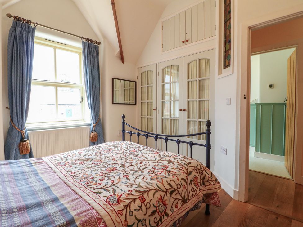 A bedroom with a bed and wardrobe at Just A Cottage, Newlands Farm in Golden Valley near Riddings and Alfreton