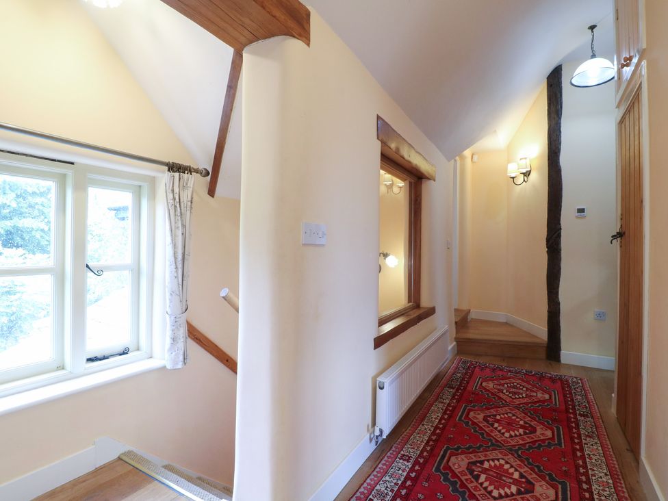 A hallway with a window and staircase at Just A Cottage, Newlands Farm in Golden Valley near Riddings and Alfreton