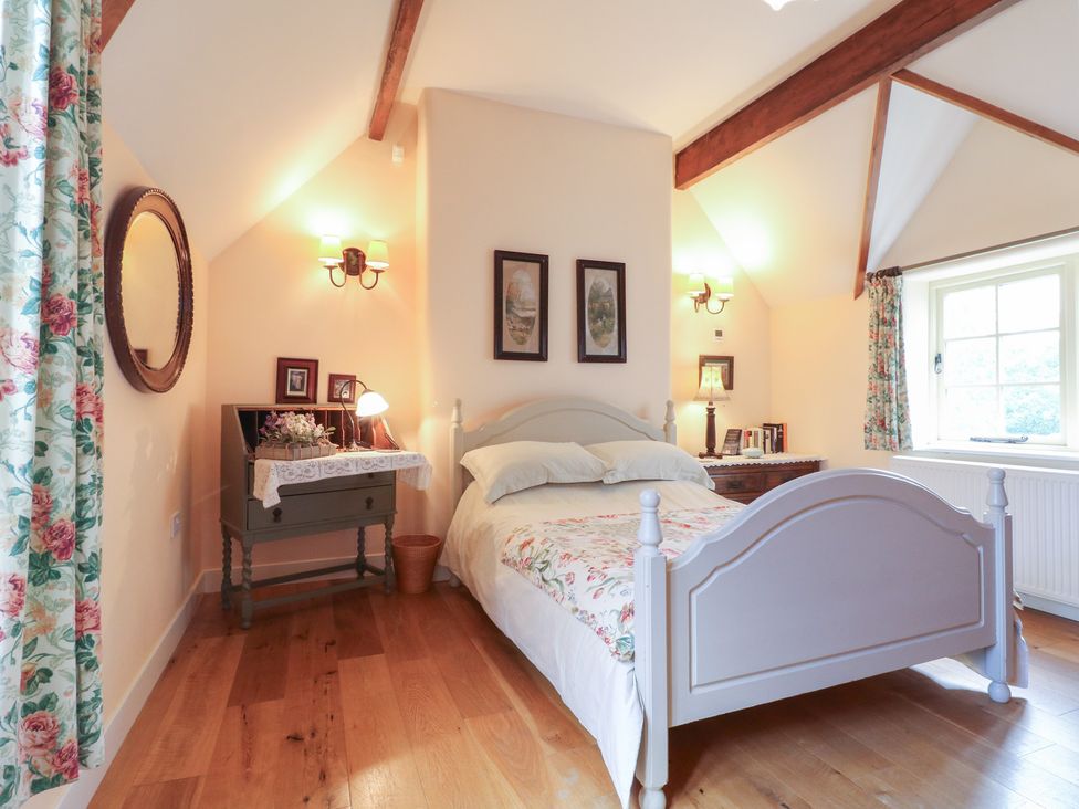 A bedroom with a bed and a dressing table at Just A Cottage, Newlands Farm, Golden Valley near Riddings and Alfreton
