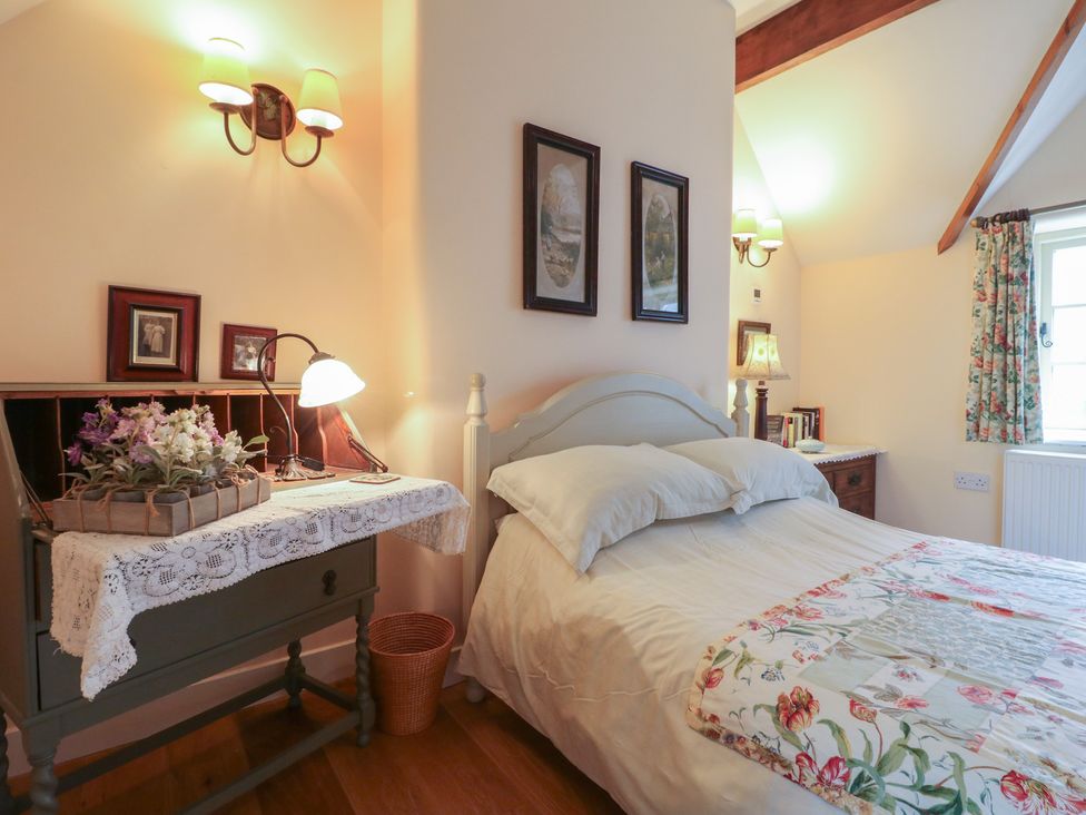 A bedroom with a bed, dresser, and pictures on the wall at Just A Cottage, Newlands Farm Golden Valley near Riddings and Alfreton