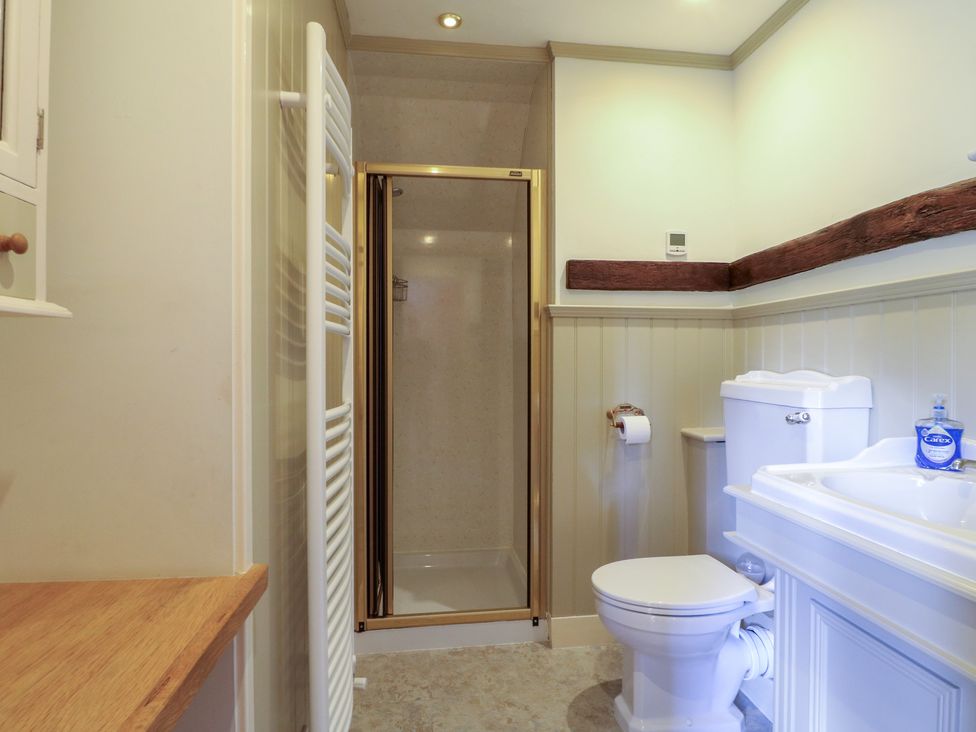 A bathroom with a toilet, sink, and shower at Just A Cottage, Newlands Farm, Golden Valley near Riddings and Alfreton