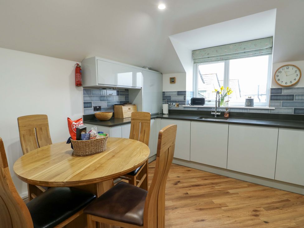 A kitchen with a table and chairs at Maelog, 14 Tides Reach Rhosneigr