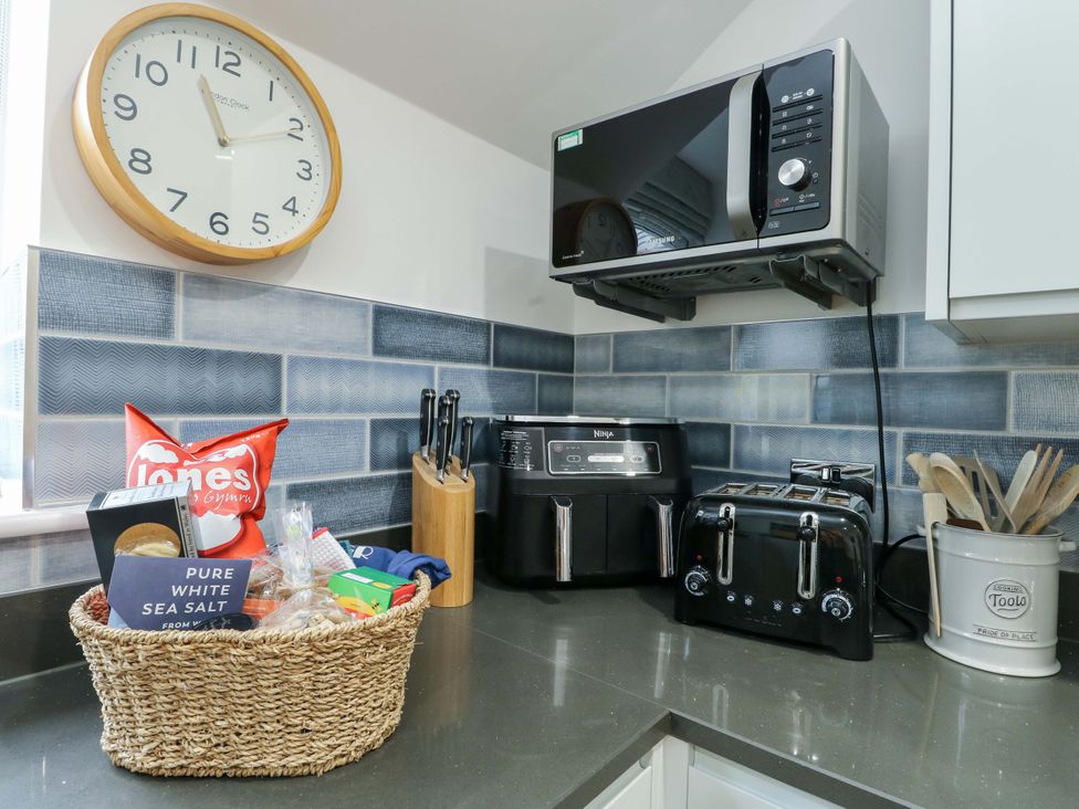 A kitchen with appliances and utensils at Maelog, 14 Tides Reach Rhosneigr