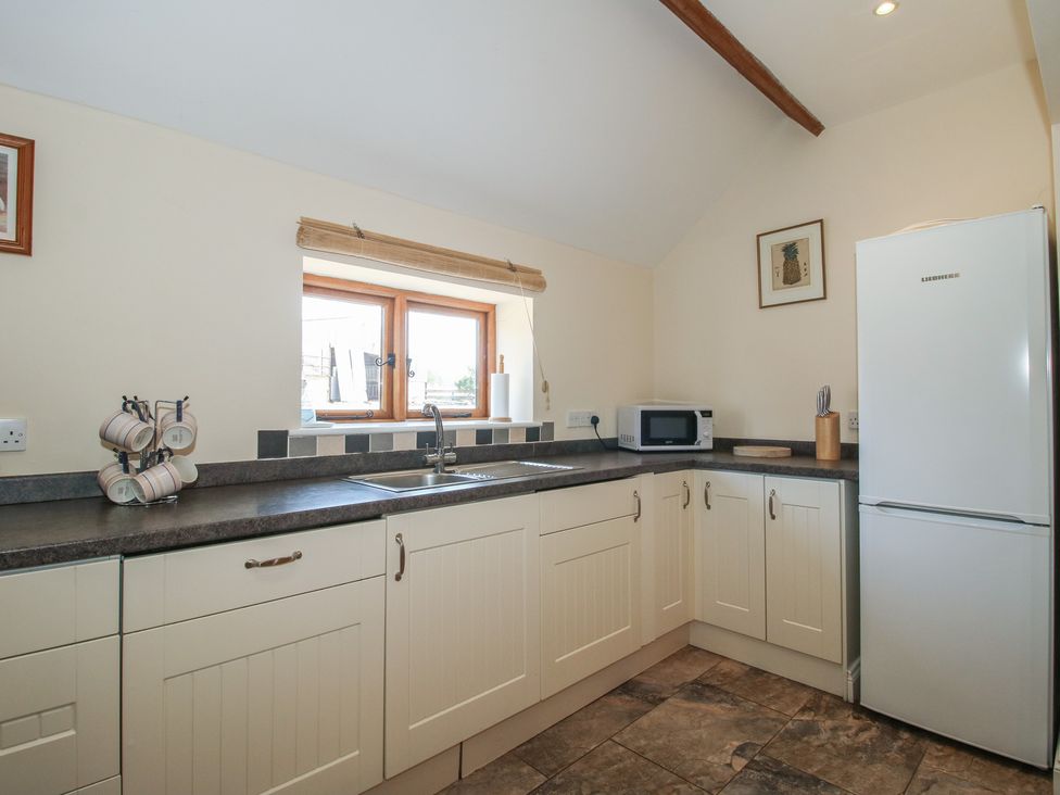 A kitchen with sink and refrigerator at The Wainhouse in Bockleton near Tenbury Wells
