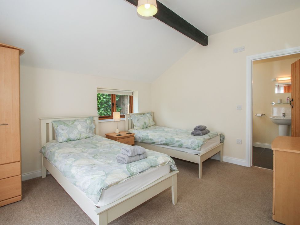 A bedroom with two single beds and a wardrobe at The Wainhouse in Bockleton near Tenbury Wells