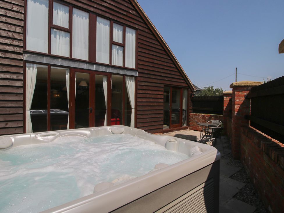 An outdoor area with a hot tub and chairs at The Wainhouse in Bockleton near Tenbury Wells