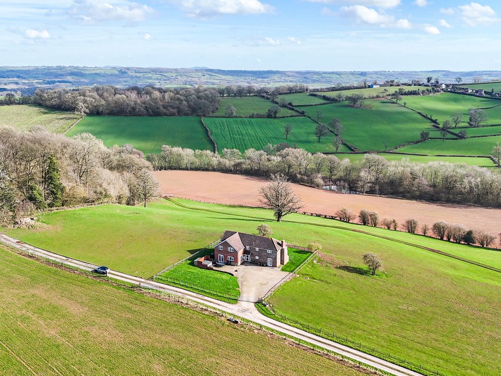 An aerial view of a house surrounded by fields at Wood Cottage in Tenbury Wells