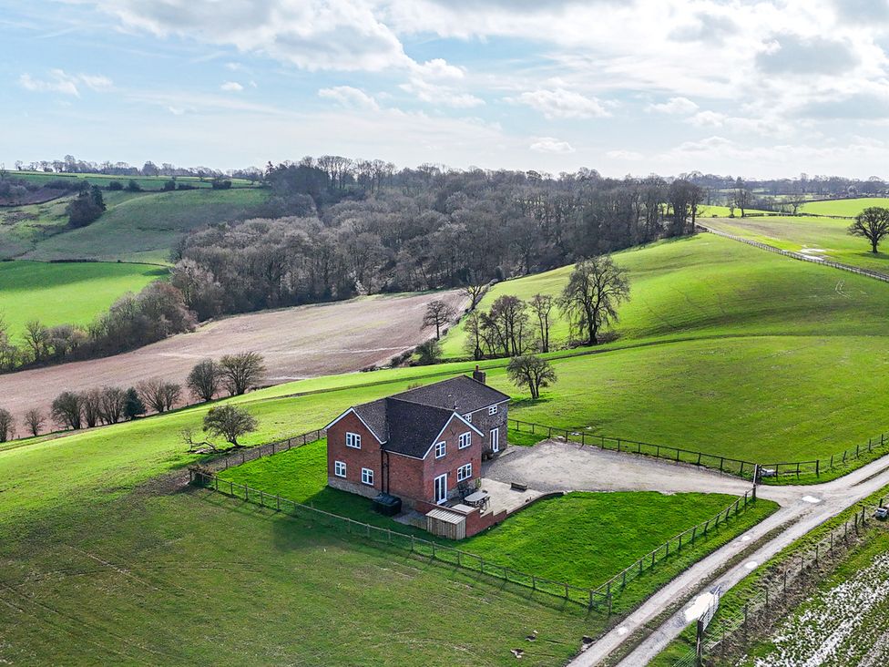 A house surrounded by fields and trees at Wood Cottage in Tenbury Wells