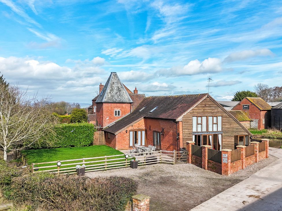 A house with a garden and gravel driveway at Wood Cottage in Tenbury Wells