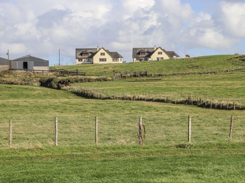 Houses and a shed in a field at Corsewall Castle Farm Lodges in Kirkcolm