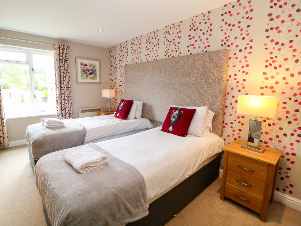 A bedroom with twin beds and a bedside table at Wensley in Matlock