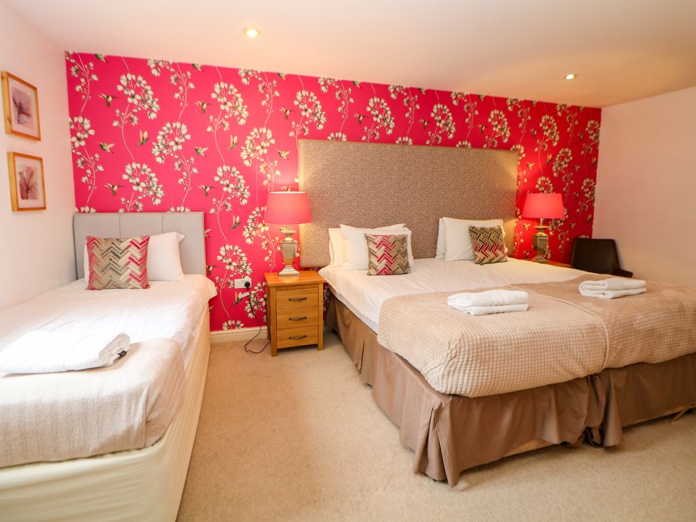 A bedroom with two beds and nightstand at Wensley in Matlock