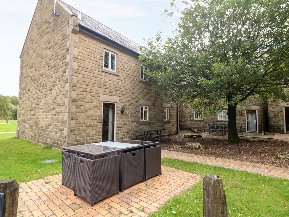 An outdoor area with a building and tables at Wensley Matlock