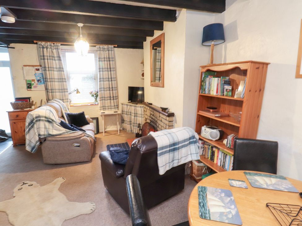 A living room with furniture including a sofa and dining table at Merlin near Llithfaen Nefyn