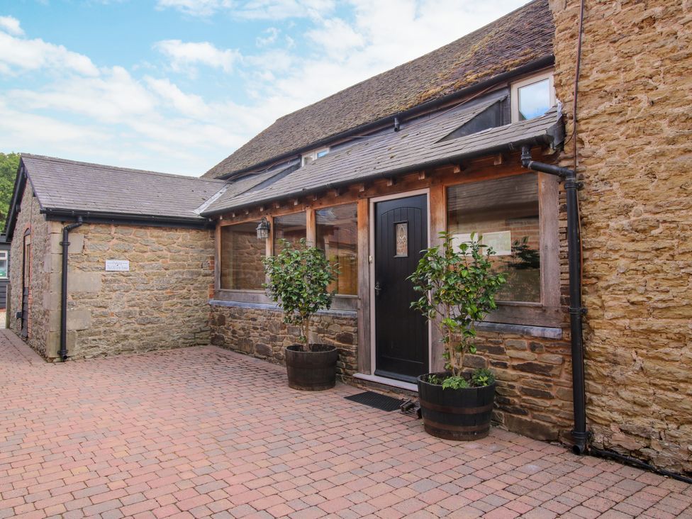 A building entrance with a door and plants at The Old Farmhouse Westhope