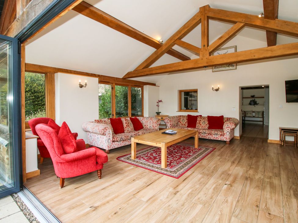 A living room with a sofa, armchair, and coffee table at The Old Farmhouse in Westhope
