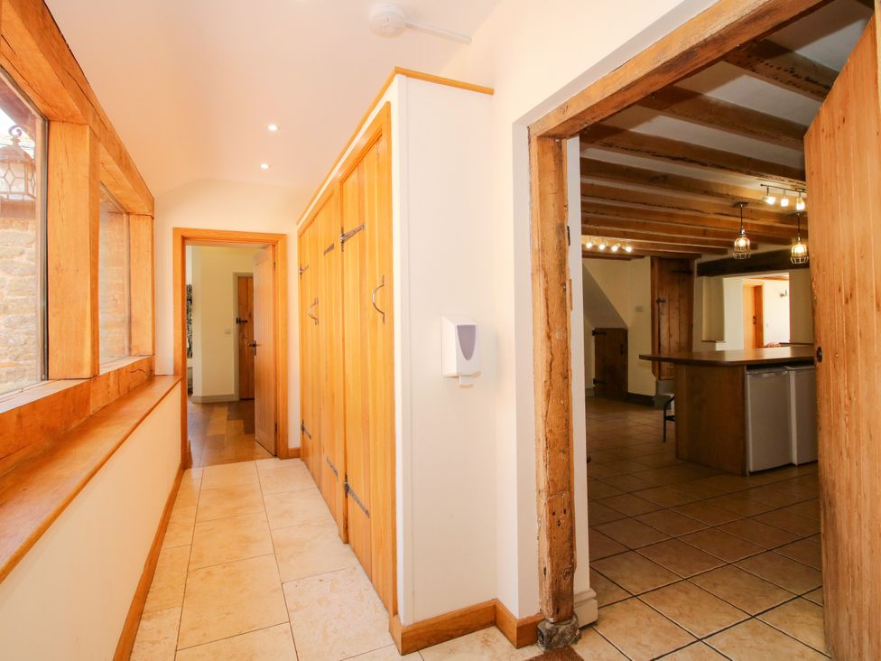 A hallway with storage cabinets and a view into the kitchen at The Old Farmhouse Westhope