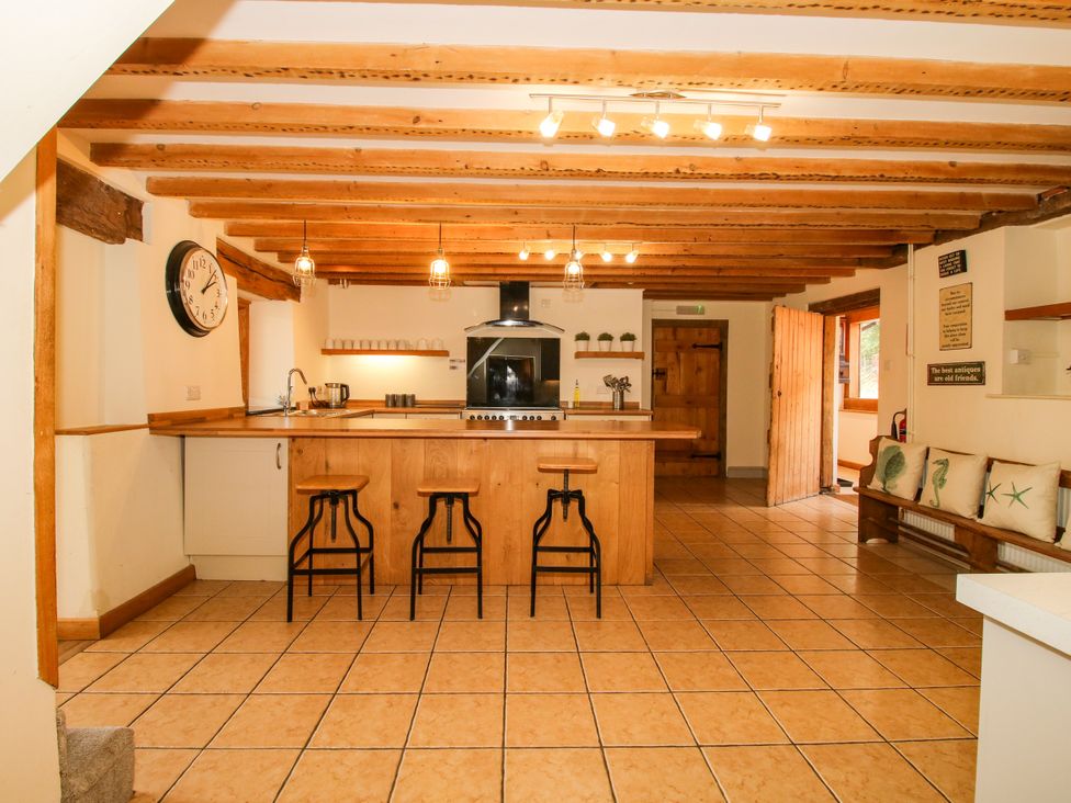 A kitchen with wooden beams and an island at The Old Farmhouse in Westhope