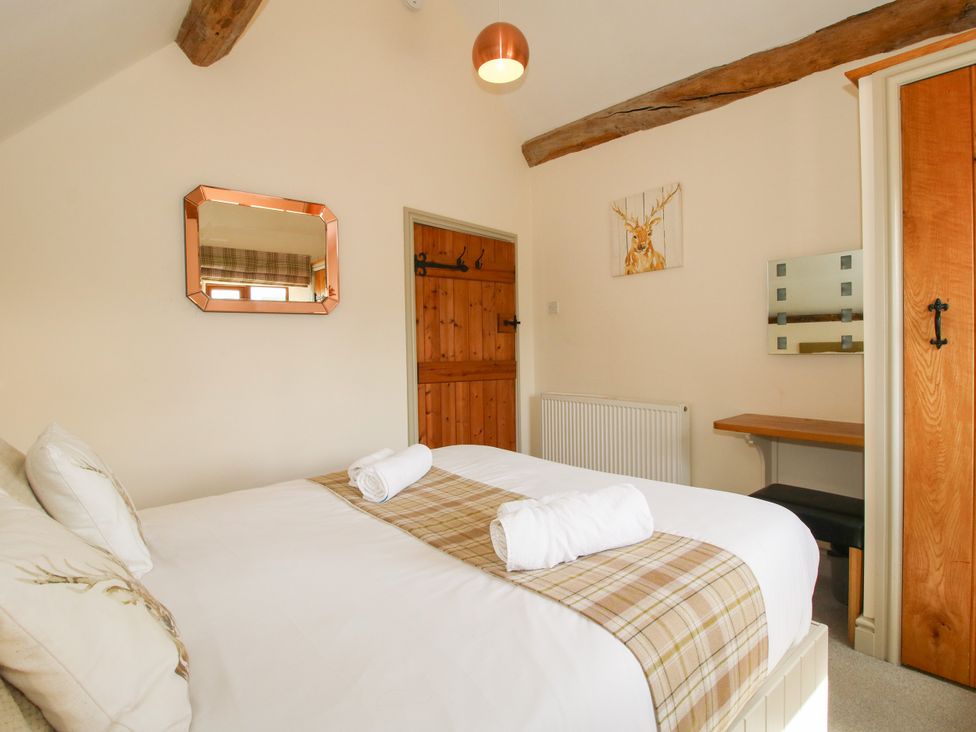 A bedroom with a bed and a mirror at The Old Farmhouse in Westhope