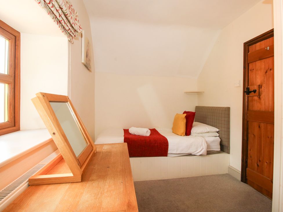 A bedroom with a bed and mirror at The Old Farmhouse in Westhope