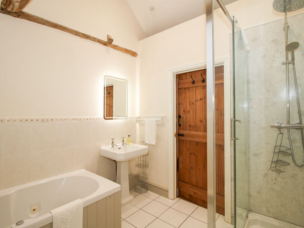 A bathroom with a bath tub and shower at The Old Farmhouse in Westhope