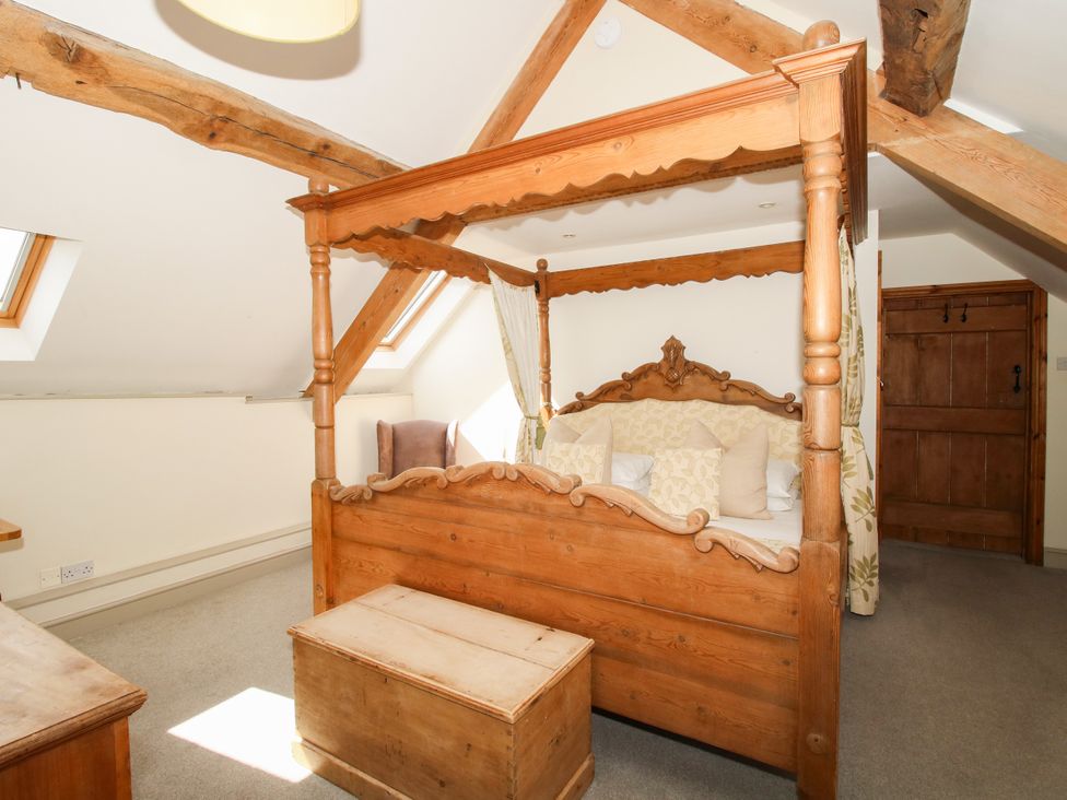 A bedroom with a canopy bed and chest at The Old Farmhouse in Westhope