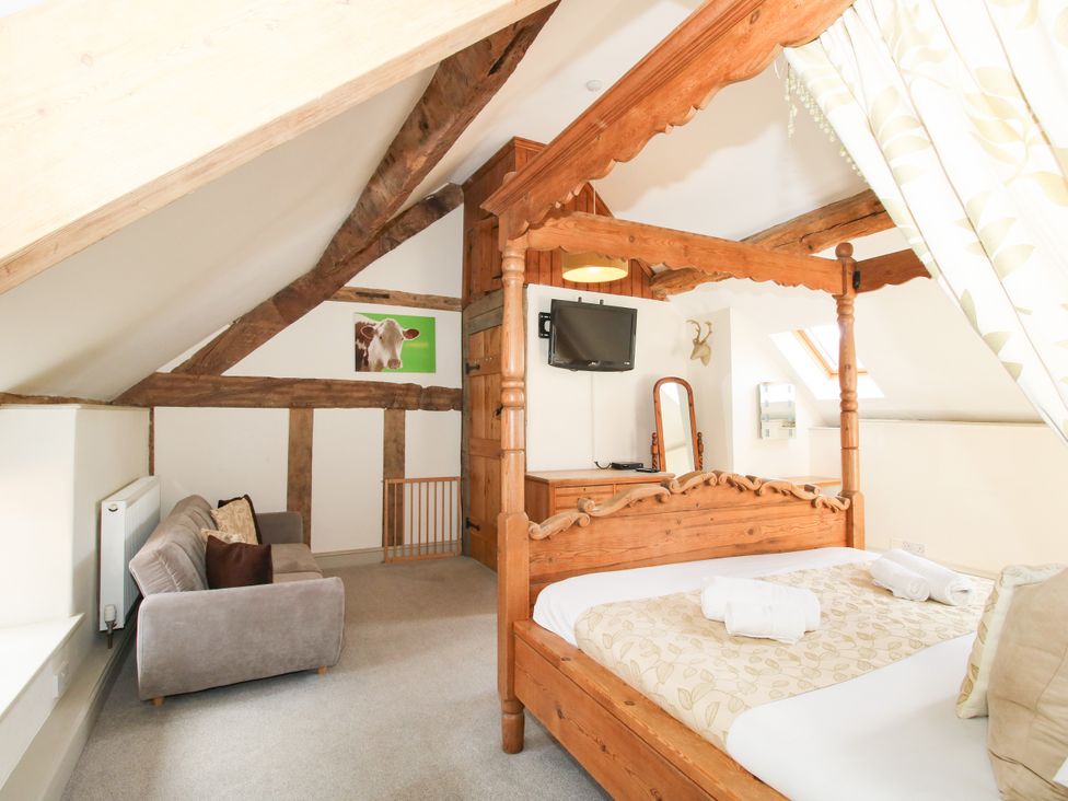 A bedroom with a four-poster bed and TV at The Old Farmhouse in Westhope