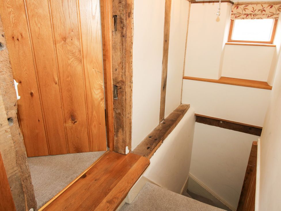 A staircase with wooden features and a door at The Old Farmhouse in Westhope