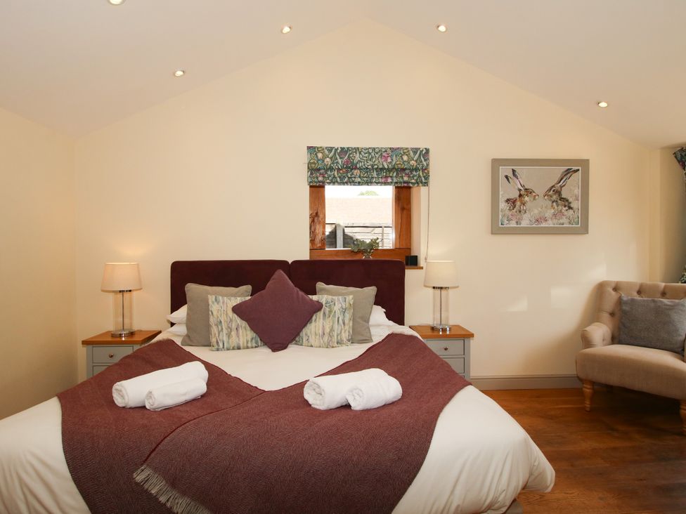 A bedroom with a bed and chair at The Old Farmhouse in Westhope