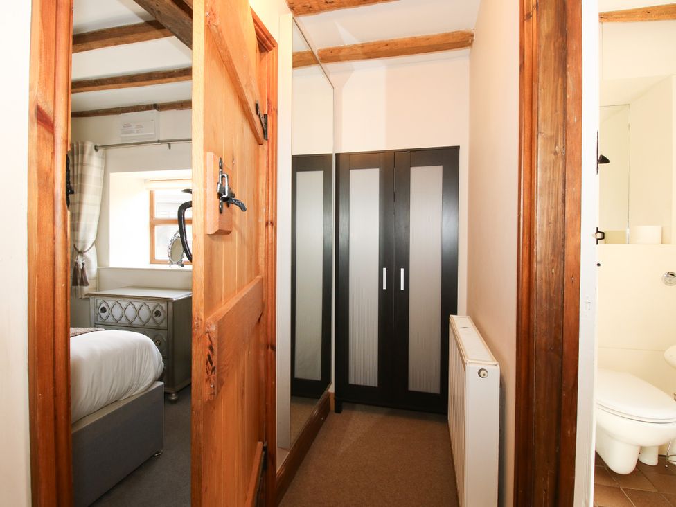 A hallway with a wardrobe and a door at The Old Farmhouse in Westhope