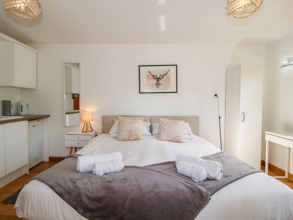 A bedroom with a bed and a kitchenette at The Old Farmhouse Westhope