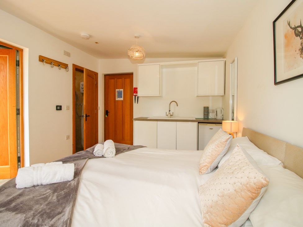 A bedroom with a bed and kitchenette at The Old Farmhouse in Westhope