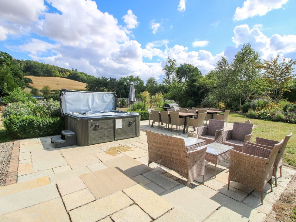 A garden with a hot tub and outdoor furniture at The Old Farmhouse in Westhope