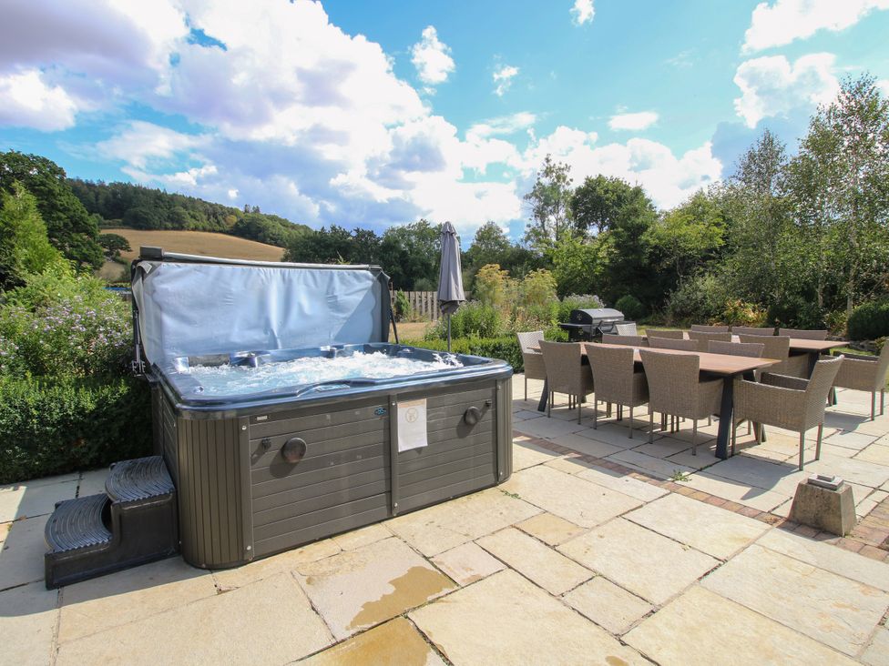 A hot tub and dining area on a patio at The Old Farmhouse in Westhope