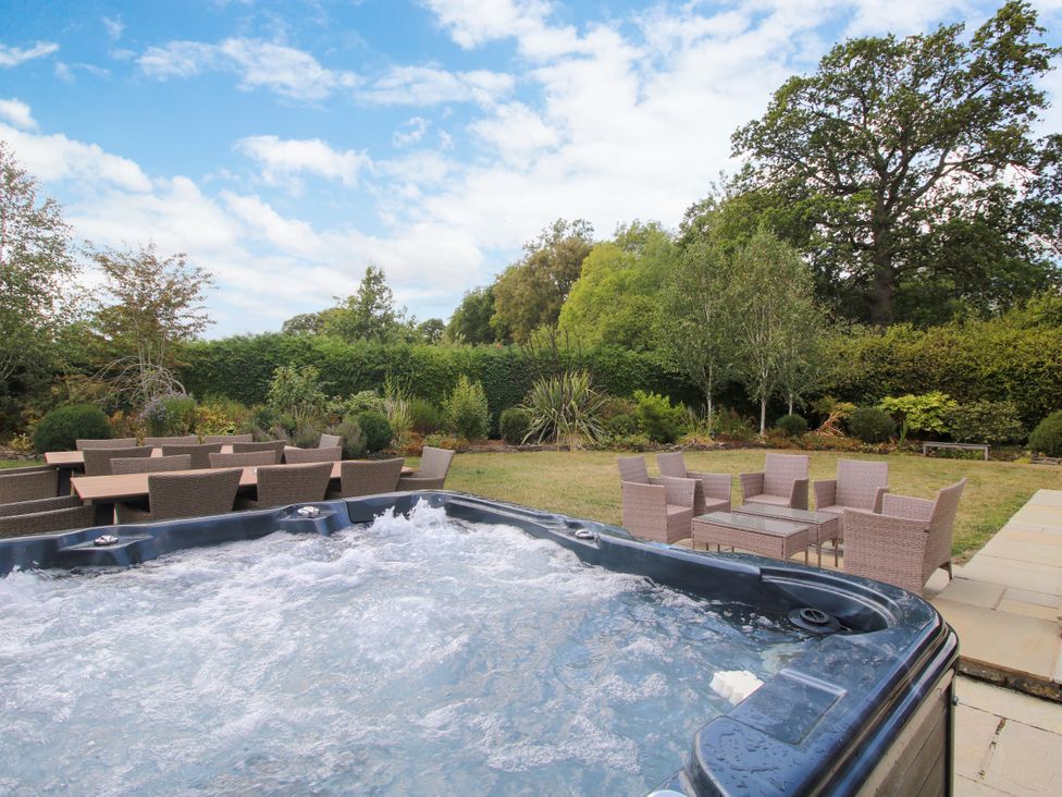 A garden with hot tub and outdoor seating at The Old Farmhouse in Westhope
